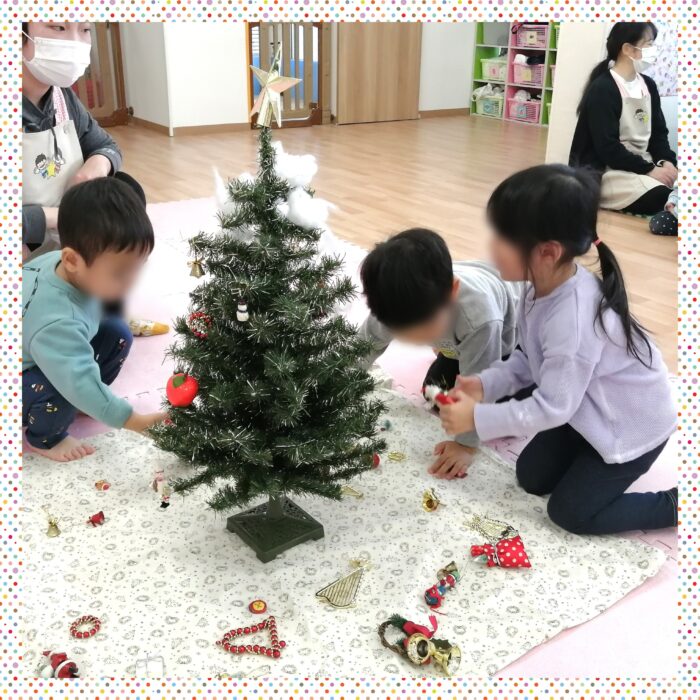 鎌ケ谷　小規模保育園　室内活動　クリスマスツリーの飾りをする児童