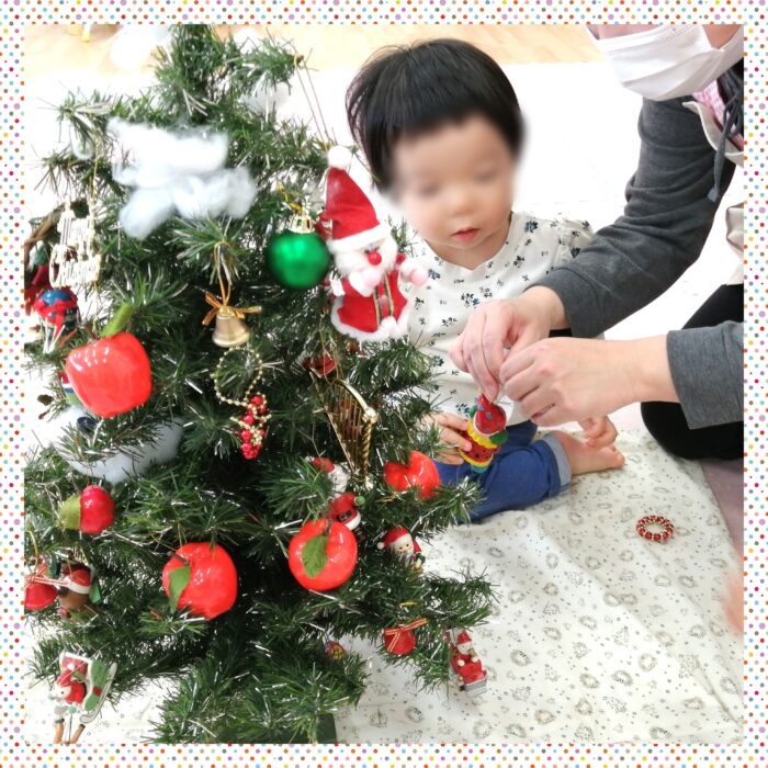 クリスマスツリーの飾りをする園児